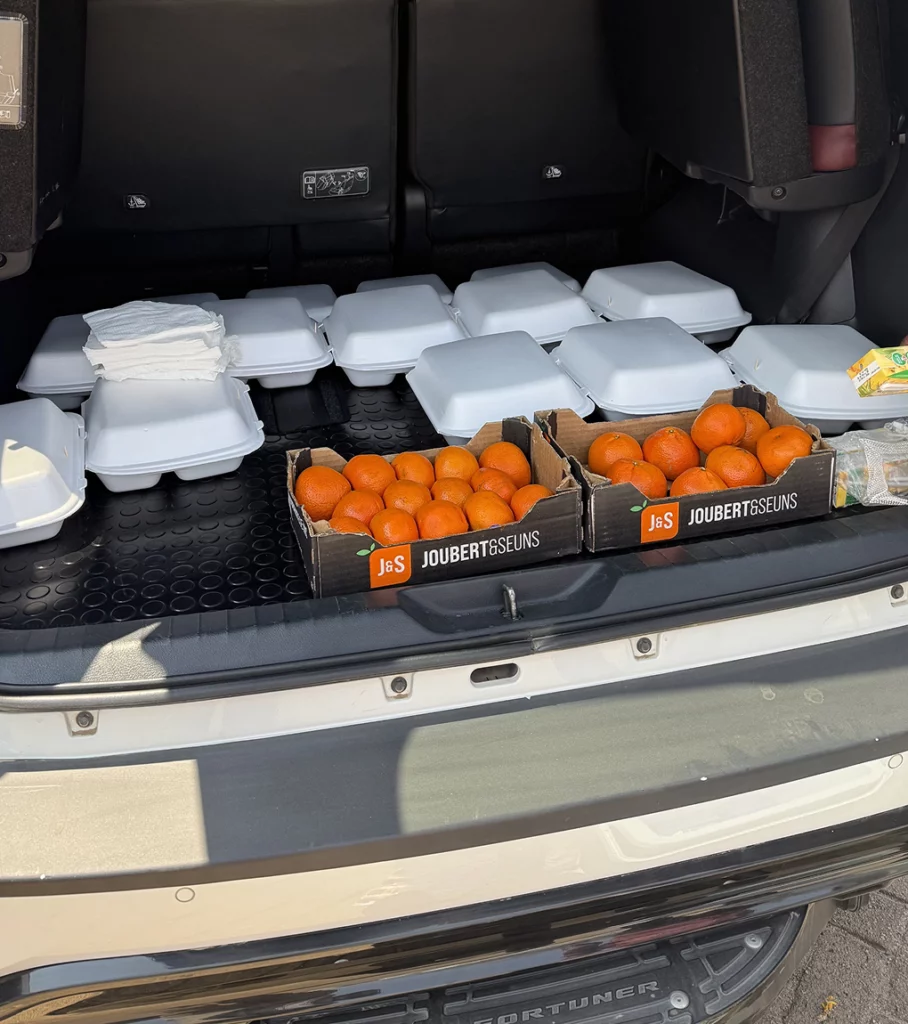 A car boot filled with oranges and packed food
